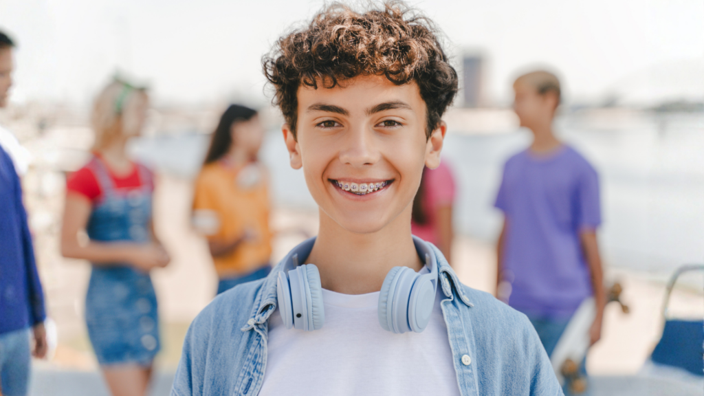 Teen smiling with braces outdoors at Obaisi Orthodontics in Chicago, IL